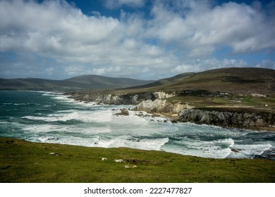 White Cliffs of Ashleam, on the Wild Atlantic Way on Achill Island, County Mayo, Ireland. Wild waves with white caps crash against the high rocks on the coast. - Shutterstock ID 2227477827