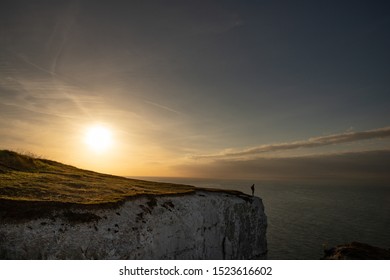 The White Cliffs Of Dover, Kent, UK With The Silhouette Of A Person Admiring The View At Sunrise - Concept Of Loneliness