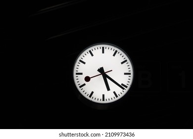 White clock on black background. There is a lot of copy space around. 