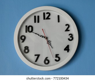 White Clock On Blue Wall Paper That Show Time Four O'clock Pm And Fifty Minutes. 
