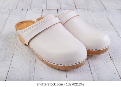 White Clogs On A White Table. Footwear Intended For Medical Personnel. Light Background.