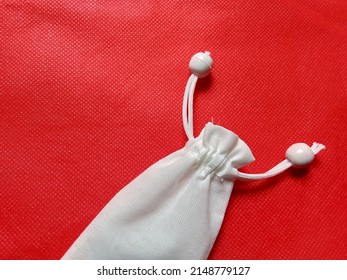 White Cloth Pouch With Red Background.