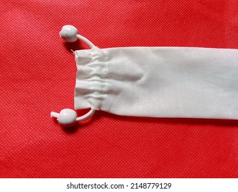 White Cloth Pouch With Red Background.