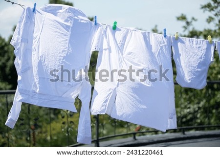 The white clothes are hung up and drying in the wind.