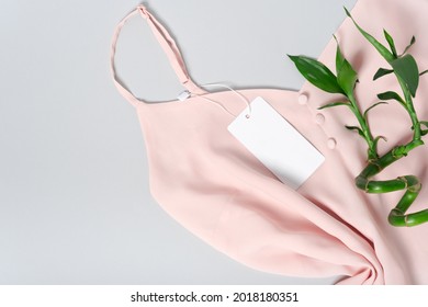 White Clothing Tag, Label Blank Mockup Template, To Place Your Design. On A Premium Cotton Pink Blouse On Gray Background. Bamboo