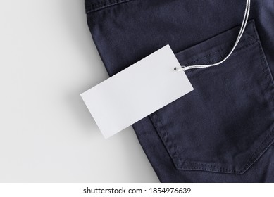 White Clothing Tag Mockup On A Blue Pants.