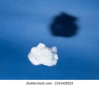 White cloud with black shadow on blue sky background. Comparison, reverse side of medal concept. Surrealism style. Hidden, invisible features. High quality photo