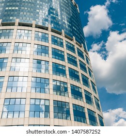 White cloud is reflected in the windows of the upper floors of the business skyscraper