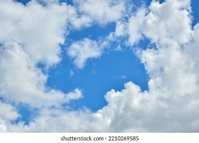 White Clouds Against Blue Sky For A Backgrounds. Puffy Fluffy White Clouds Against Daytime Sky. Cumulus Is A Fluffy Cloud Like A Cotton Ball