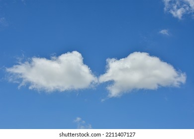 White Clouds Against Blue Sky For A Backgrounds. Puffy Fluffy White Clouds Against Daytime Sky. Cumulus Is A Fluffy Cloud Like A Cotton Ball