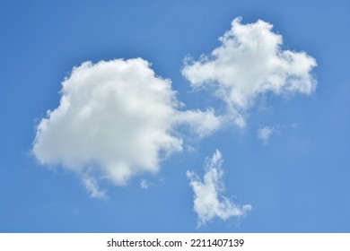 White Clouds Against Blue Sky For A Backgrounds. Puffy Fluffy White Clouds Against Daytime Sky. Cumulus Is A Fluffy Cloud Like A Cotton Ball