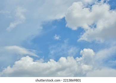 White Clouds Against Blue Sky For A Backgrounds. Puffy Fluffy White Clouds Against Daytime Sky. Cumulus Is A Fluffy Cloud Like A Cotton Ball