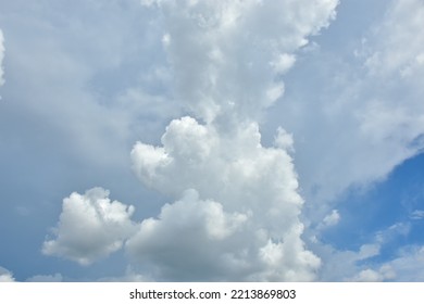 White Clouds Against Blue Sky For A Backgrounds. Puffy Fluffy White Clouds Against Daytime Sky. Cumulus Is A Fluffy Cloud Like A Cotton Ball