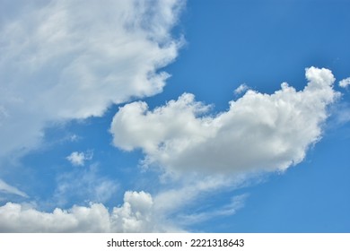 White Clouds Against Blue Sky For A Backgrounds. Puffy Fluffy White Clouds Against Daytime Sky. Cumulus Is A Fluffy Cloud Like A Cotton Ball