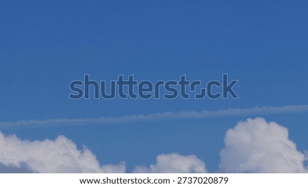 White clouds forming thin linear streaks across a blue sky. Minimal and natural sky background suitable for design projects, abstract compositions, nature themes, weather concepts, and clean visual layout