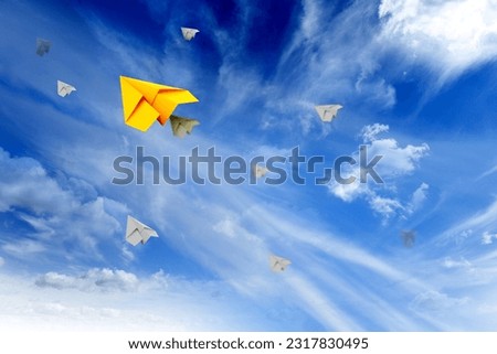 White clouds and paper airplanes flying in blue sky on sunny day