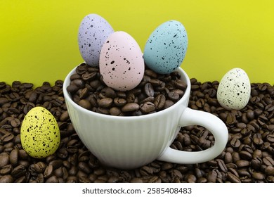 A white coffee cup with Easter eggs. The Easter eggs are in different colors, and the cup is filled with coffee beans. Concept of warmth and comfort, as the coffee. Coffee break.