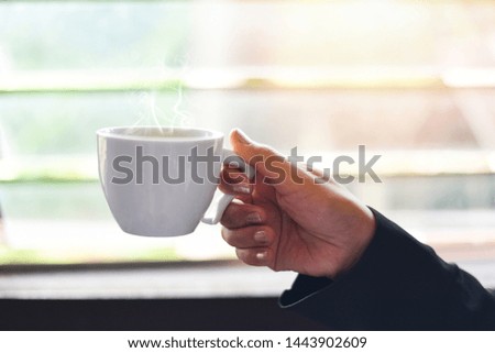 Similar – Foto Bild Frau Hand, die eine Tasse Kaffee von einem Holztisch im Garten aufzieht.