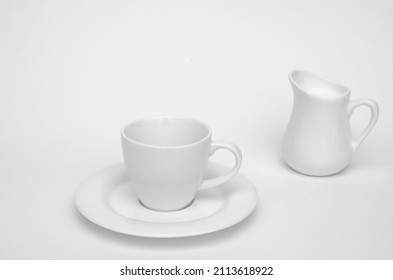 White Coffee Cup And Milk Jug With Milk On White Background