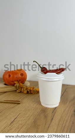 White coffee cup mockup with autumn fall home decor, pumpkins, Red pepper, cup of coffee. Halloween concept.