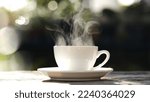 White coffee cup, mug with steaming smoke of coffee on old wooden table in morning nature outdoor, garden background, 4K. Hot Coffee Drink, Beverage Concept.