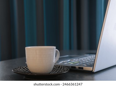 White coffee cup next to a laptop with a professional blue background in the workspace of a businessman - Powered by Shutterstock