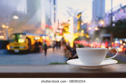 White coffee cup on brown timber with defocus of food trucks and bokeh lights background - Powered by Shutterstock