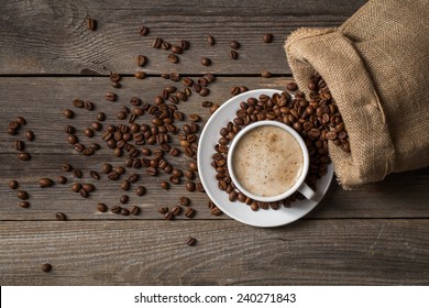 White coffee cup with opened bag. Mug standing on wooden table. - Powered by Shutterstock