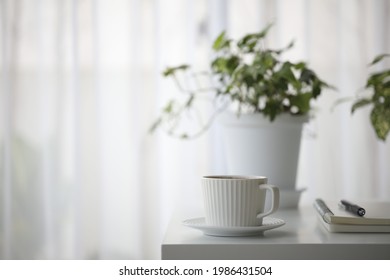 white coffee cup and plant pot on white table minimal interior - Powered by Shutterstock