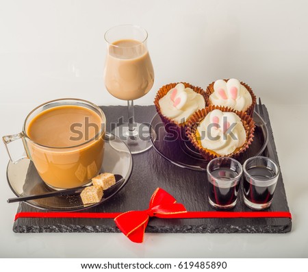 White coffee in modern glass cup, muffins with Easter decoration, red bow, milk drink, coffee set