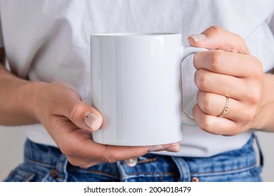 White coffee mug in the hands of the girl for presentation custom sublimation print. Blank mug photo mockup template - Shutterstock ID 2004018479