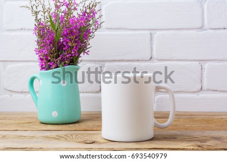 White coffee mug mockup with maroon purple field flowers in polka dot mint green pitcher vase.  Empty mug mock up for design promotion.  