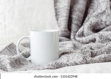 White Coffee Mug Mockup On The Bed With Gray Blanket