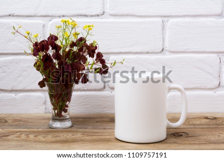 White coffee mug mockup with yellow and maroon wild grass in the simple glass vase.  Empty mug mock up for design promotion.  