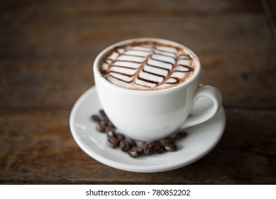 White coffee mug on patterned old wooden floor, coffee cup on the older wooden floor, black coffee, Americano, vertical picture.
