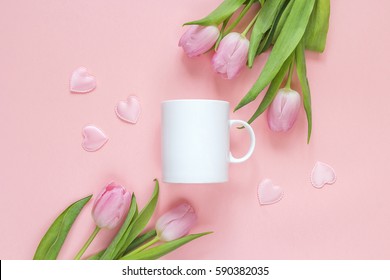 White Coffee Mug With Pink Tulips And Hearts On A Pink Background. Space For Text Or Design. Romantic Or Mother Day Concept.
