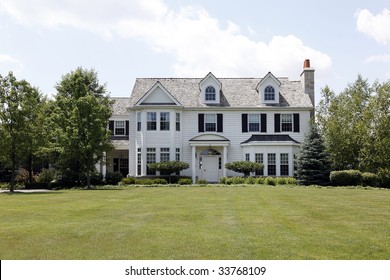 White Colonial Home In Suburbs With Columns