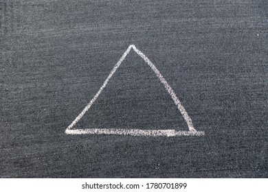 White Color Chalk Hand Drawing In Triangle Shape On Black Board Background