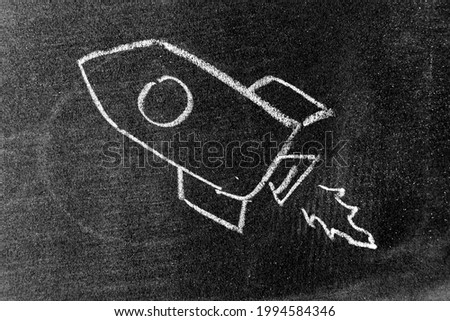 White color chalk hand drawing in rocket shape on blackboard or chalkboard background (Concept for new experience, start up the business)