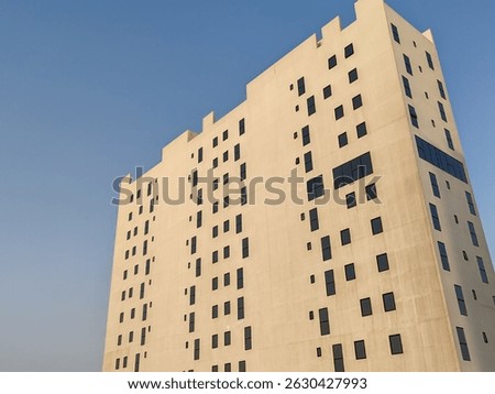 White Color Commercial Residential Building Complex with Black Color Windows And Blue Sky Background. Highrise Skyscraper Building Exterior Outdoor Full View. G+10 floor Tallest Skyline With PentHouse