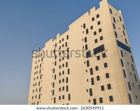 White Color Commercial Residential Building Complex with Black Color Windows And Blue Sky Background. Highrise Skyscraper Building Exterior Outdoor Full View. G+10 floor Tallest Skyline With PentHouse