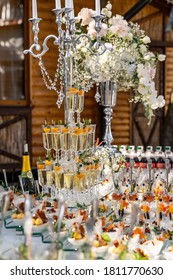 White Color Wedding Table Decorated With Candelstick. Flowers, Candles And Glasses With Champagne. Closeup.