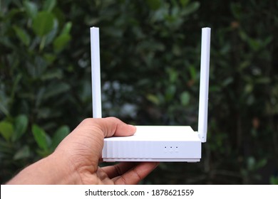 White color WiFi Router on hand photo capture at Dhaka, Bangladesh.
