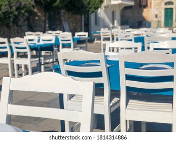 White Colored Wooden Chairs And Tables Of An Open Air Restaurant