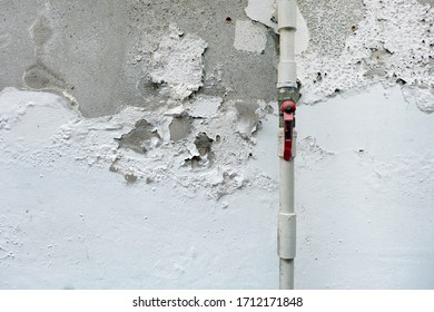 White colour peeling from concrete wall outdoor side in old house because of rain and humid.