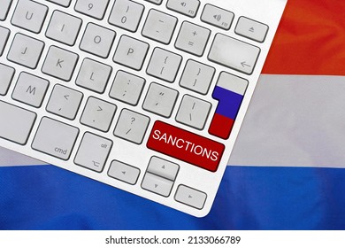 White Computer Keyboard With Button Of Flag Russia And Red Button With Word Of Sanctions On Netherlands Flag Background. Financial And Economic Regulation Sanctions Dutch Against Of Russia