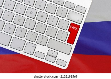White computer keyboard and red button with word Fake on Russia flag backgroun. Fake news in Russia. War Information Technology