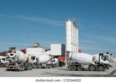 White concrete mixers standing by a modern concrete plant.