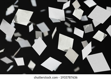 White confetti falling down on black background