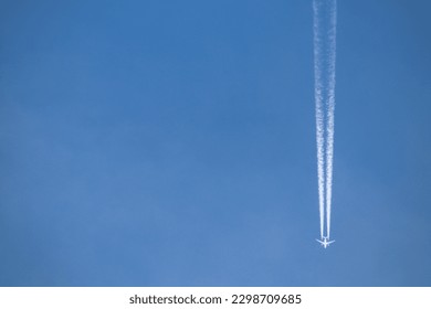 The white contrail left by the airplane flying across the blue sky.
